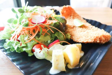 Domates soslu kızarmış balık ve salata ya da soslu balık ve patates kızartması.