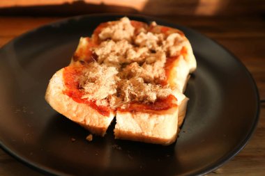 Tereyağlı tost ve kurutulmuş domuz eti ya da kızarmış ekmek.