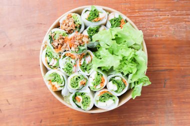 Pirinç dürümleri, taze ekmekler veya sebzeli börekler veya kutuda domuz dürümleri ve sosisler.