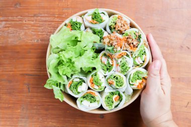 Pirinç dürümleri, taze ekmekler veya sebzeli börekler veya kutuda domuz dürümleri ve sosisler.