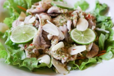 Haşlanmış domuz salatası, baharatlı domuz salatası, marul, sarımsak ve limon.