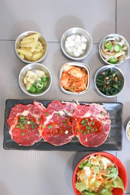 Çiğ et, dilimlenmiş sığır eti veya aşçı için sığır eti ve servis için Kore salatası