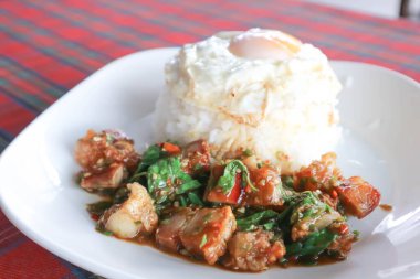 Fesleğenli ve pirinçli kızarmış domuz, yumurtalı güneşli tarafı ya da fesleğenle kızarmış domuz pastırması ya da Tayland yemeği.