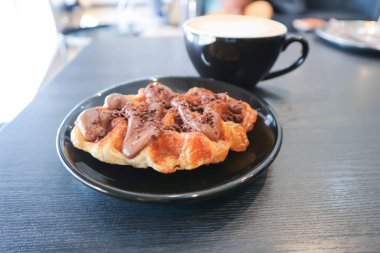 Çikolatalı waffle ya da çikolatalı waffle ve sıcak kahve.