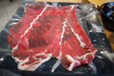 Çiğ et, dilimlenmiş sığır eti ya da aşçı için domuz eti.