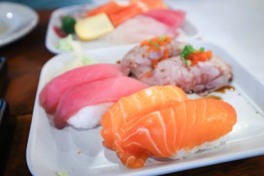 Somon balığı, ton balığı ve sığır suşisi ya da Japon yemeği ile kaplanmış somon ya da pirinç.