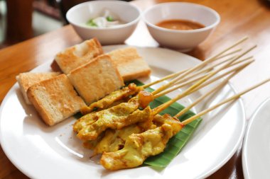 Kızarmış ekmek ve soslu domuz eti, satay.