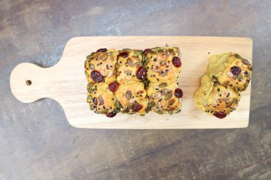 kabak ekmeği ya da somun ekmek kabak tohumu, kızılcık ve susam soslu ahşap tepside