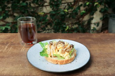 Yumurtalı ekmek, marul ve mantarlı sos ve servis için amerikano kahvesi veya çay.