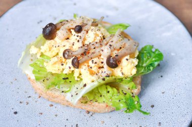 Servis için yumurta, marul ve mantar soslu ekmek.