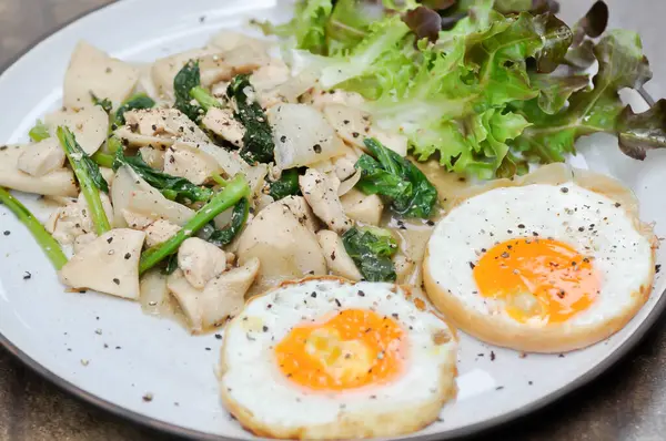 stock image stir-fried chicken with mushroom and kale , sunny side up egg and lettuce for serve