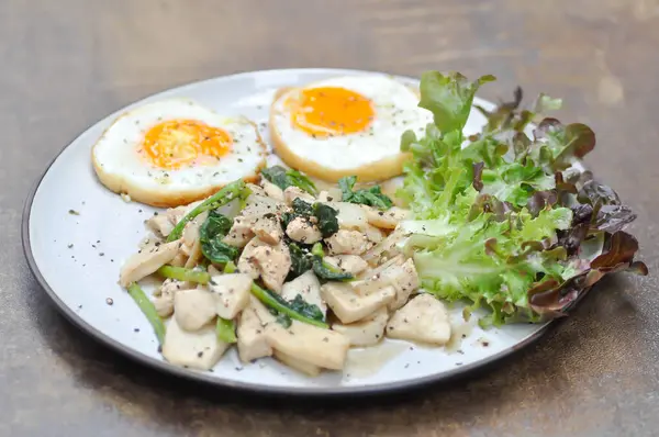 stock image stir-fried chicken with mushroom and kale , sunny side up egg and lettuce for serve