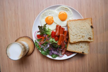 Kahvaltı ya da ekmek yanında yumurta, sosis ve sebze ve sıcak kahve.