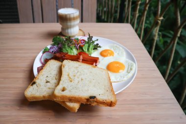 Kahvaltı ya da ekmek yanında yumurta, sosis ve sebze ve sıcak kahve.