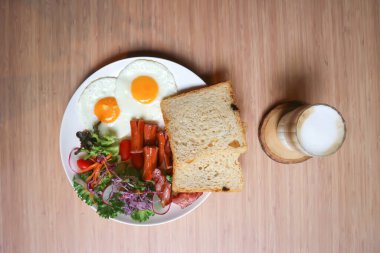 Kahvaltı ya da ekmek yanında yumurta, sosis ve sebze ve sıcak kahve.