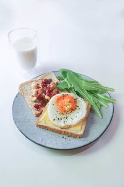 Yumurta ve peynirli ekmek ya da yumurta, marul ve bademi kurutulmuş yaban mersini ve sütle servis etmek.