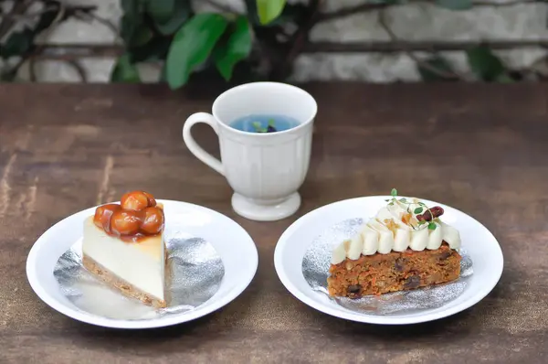 stock image carrot cake with cream and walnut topping ,caramel macadamia cheesecake and butterfly pea tea for serve