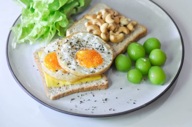 Kahvaltıda yumurta, fındık, üzüm ve marullu tost veya ekmek.