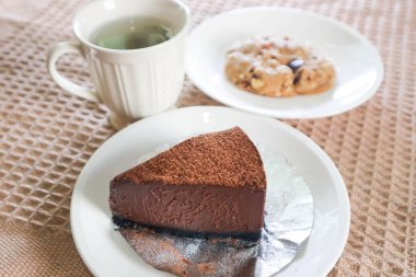 chocolate cake , hot tea and cookie for serve clipart