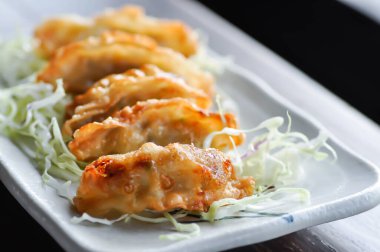 Çin mantısı, hamur tatlısı veya wonton veya kızarmış wonton veya gyoza veya Japon usulü kızarmış mantı ve lahana.