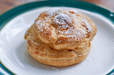 Choux kreması ya da kremalı pasta, küçük bir tabakta yanar döner.