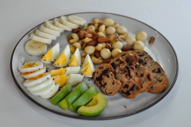 kaynamış yumurta, avokado, muz ve fındıklı yaban mersinli ekmek veya kızılcık ekmeği servis etmek için.