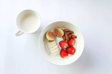Meyve soslu yoğurt veya çilekli, incirli badem ve muzlu yoğurt ve servis için süt.