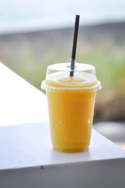 Plastik bardakta mango suyu veya mango püresi.