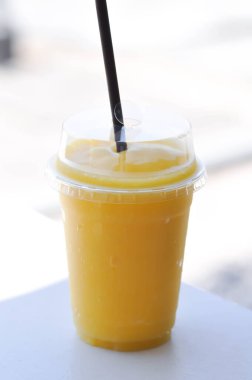 Plastik bardakta mango suyu veya mango püresi.