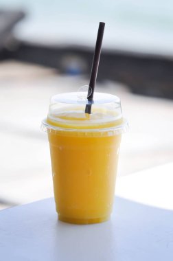 Plastik bardakta mango suyu veya mango püresi.
