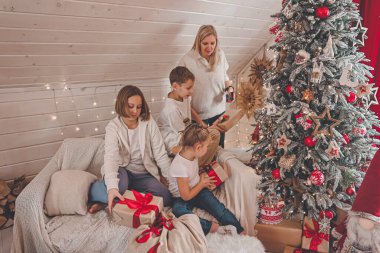 Çocuklar ve anne Noel ağacını süslüyor, Mutlu Noeller ve yeni yıl tatilleri. Aile, kış tatili ve insan konsepti, portre seven aile, yakın çekim..