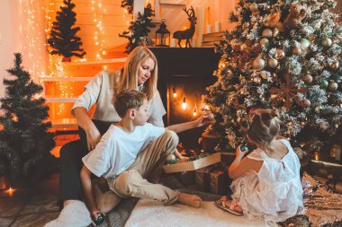 mutlu bir aile ile boubles ve oturma odasında hediyeleri Noel ağacı süsleme