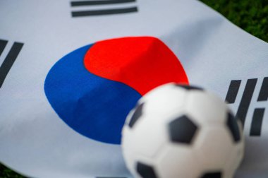 Güney Kore Milli Futbol Takımı. Ulusal Bayrak yeşil çimlerde ve futbol topunda. 2022 yılında şampiyonluk ve turnuva için futbol duvar kâğıdı. Dünya çapında maç.