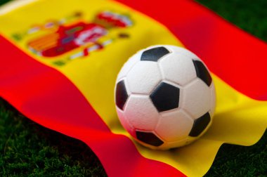 İspanya Milli Futbol Takımı. Ulusal Bayrak yeşil çimlerde ve futbol topunda. 2022 yılında şampiyonluk ve turnuva için futbol duvar kâğıdı. Dünya çapında maç.