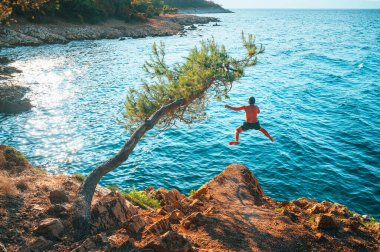 Mavi Akdeniz 'in suyuna atlayan adam. Hırvatistan 'da aktif yaz tatili. Enerji dolu fotoğraf, boşluğu düzenle