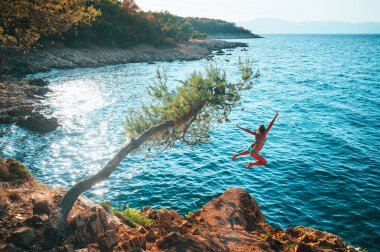 Mavi Akdeniz 'in suyuna atlayan adam. Hırvatistan 'da aktif yaz tatili. Enerji dolu fotoğraf, boşluğu düzenle