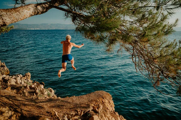 stock image Sport at Summer Vacation in Croatia. Man jumping to the water and enjoy holiday