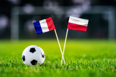 Fransa, Polonya. Sekiz final, 16. raunt futbol maçı. El yapımı ulusal bayraklar ve yeşil çimlerin üzerinde futbol topu. Arka planda futbol stadyumu var. Siyah boşluk.
