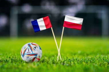 Katar, Doha, 29 Kasım 'da. 2022: Fransa - Polonya. 16. raunt futbol maçı. Fifa Dünya Kupası resmi topu Katar 2022 yeşil çimlerde. Arka planda futbol stadyumu ve el yapımı ulusal bayraklar..