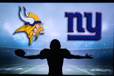 MINNESOTA, USA, JANUARY 10, 2023: New York Giants vs. Minnesota Vikings. NFL Wild Card Round 2023, Silhouette of NFL player of american football. holding ball in hand. Big screen in background