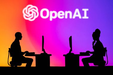 NEW YORK, USA, 25. JANUARY 2023: Open AI Web Developers at Work. Man and woman software engineers sitting in open office. Logo of Open AI in background. Brainstorm, Artificial Intelligence. Teamwork