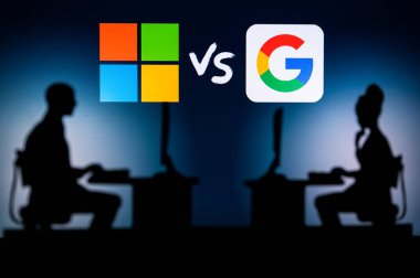 USA, NEW YORK CITY, JANUARY 30, 2023: Microsoft vs Google. Pushing Boundaries with Cutting-Edge Software: Two Developers Silhouetted with Company Logo in Background.