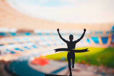 Canlandırıcı Bitiş: Silhouetted Runner Modern Atletizm Stadyumu 'nda Zafer İddia Etti. Alan, İz ve Alan Yarışması Fotoğrafını Düzenle.