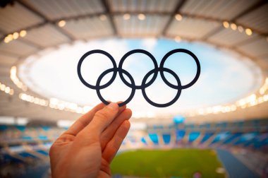 PARIS, FRANCE, 7 Temmuz 2023: Sembolik Bağlantı: Atletin Eli Olimpiyat Yüzükleriyle Tanışıyor, Paris 2024 Yaz Olimpiyat Oyunlarını Yansıtıyor