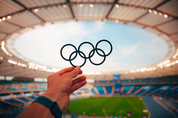 PARIS, FRANCE, JULY 7, 2023: Athlete Holds Olympic Rings Symbol with Pride. Photo for Summer Olympic Games in Paris 2024.
