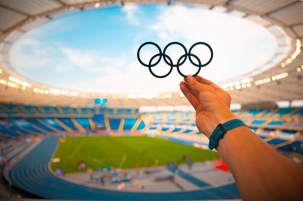 PARIS, FRANCE, JULY 7, 2023: Athlete's Reverence for Olympic Rings at Modern Stadium. Photo for Summer Olympic Games in Paris 2024