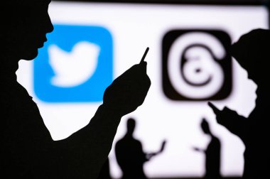 California, Birleşik Devletler, 7 Temmuz 2023: Başlık Uygulaması ve Twitter. Akıllı telefonda konuşan bir adamın silueti. Arka planda sosyal medya sembolü
