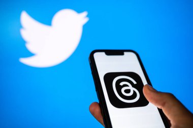 CALIFORNIA, UNITED STATES, 7 Temmuz 2023: Akıllı telefondaki kullanıcı uygulaması ve arka plandaki Twitter logosu. Sohbet ve mikro blog sosyal medya uygulamalarının büyük çakışması.