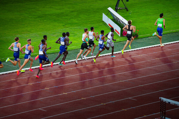 Male Athletes Competing in Middle Distance Race on Outdoor Track and Field Stadium - Track and Field Illustration Photo for Worlds in Budapest and Games in Paris