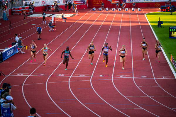 B. BYSTRICA, SLOVAKIA, JULY 20, 2023: Female Sprinters Competing in 100m Race Under Stunning Sunset Light: Track and Field Event for Worlds in Budapest and Summer olympic Games in Paris